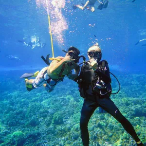 Two Snuba divers pose for a photo underwater in Maui, Hawaii